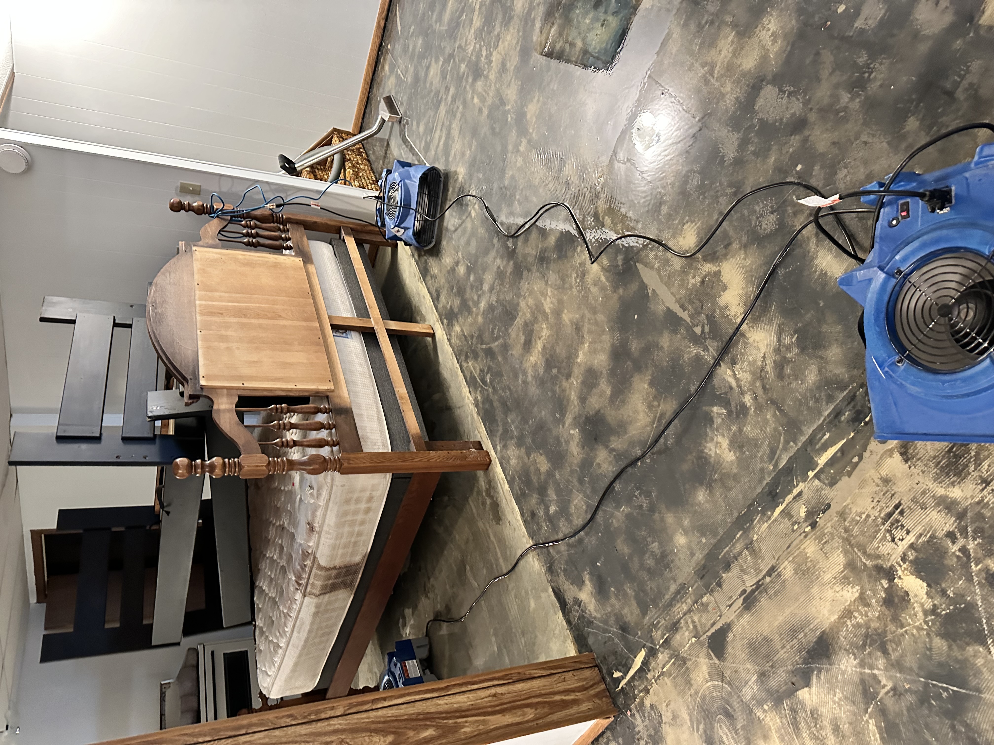 Fire and water damage restoration specialists working on bedroom with professional drying equipment in Twin Cities Minnesota