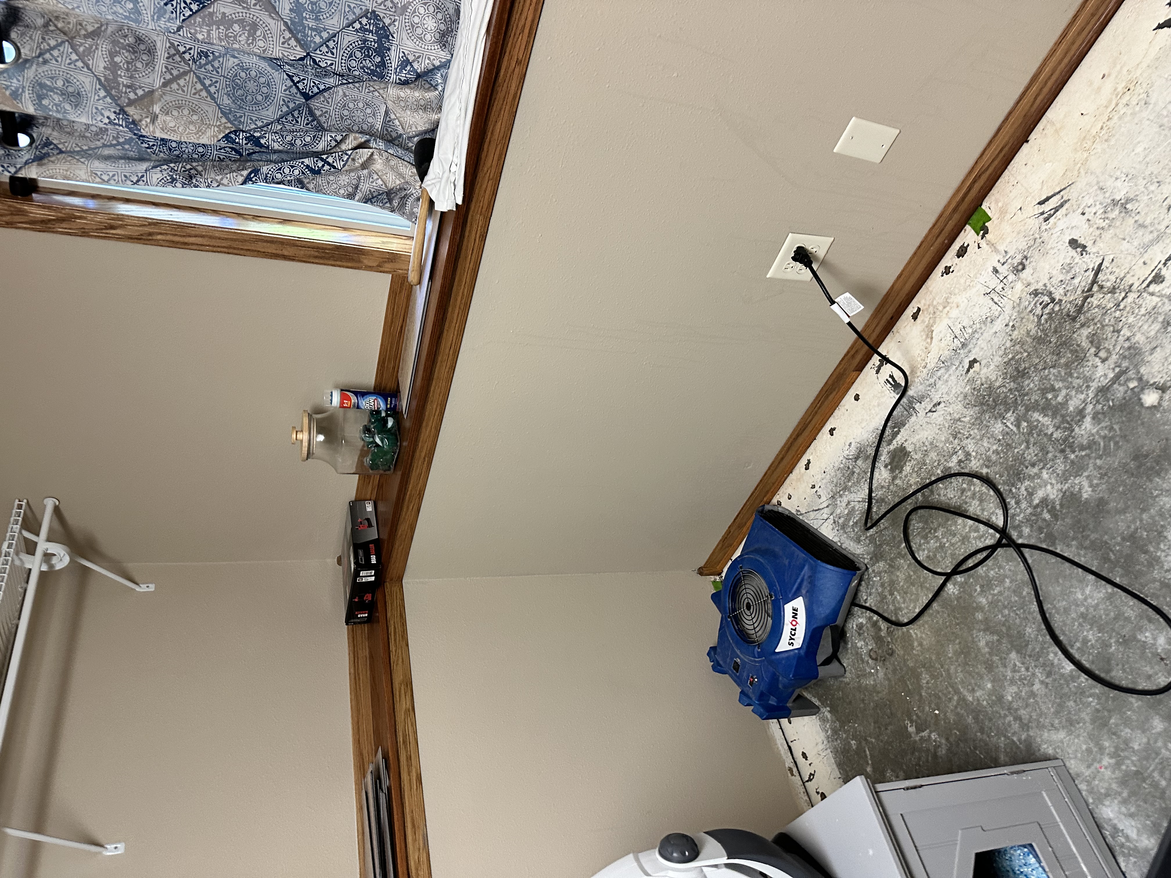 Water damage restoration in laundry room with blue air mover equipment and damaged flooring Minneapolis Minnesota