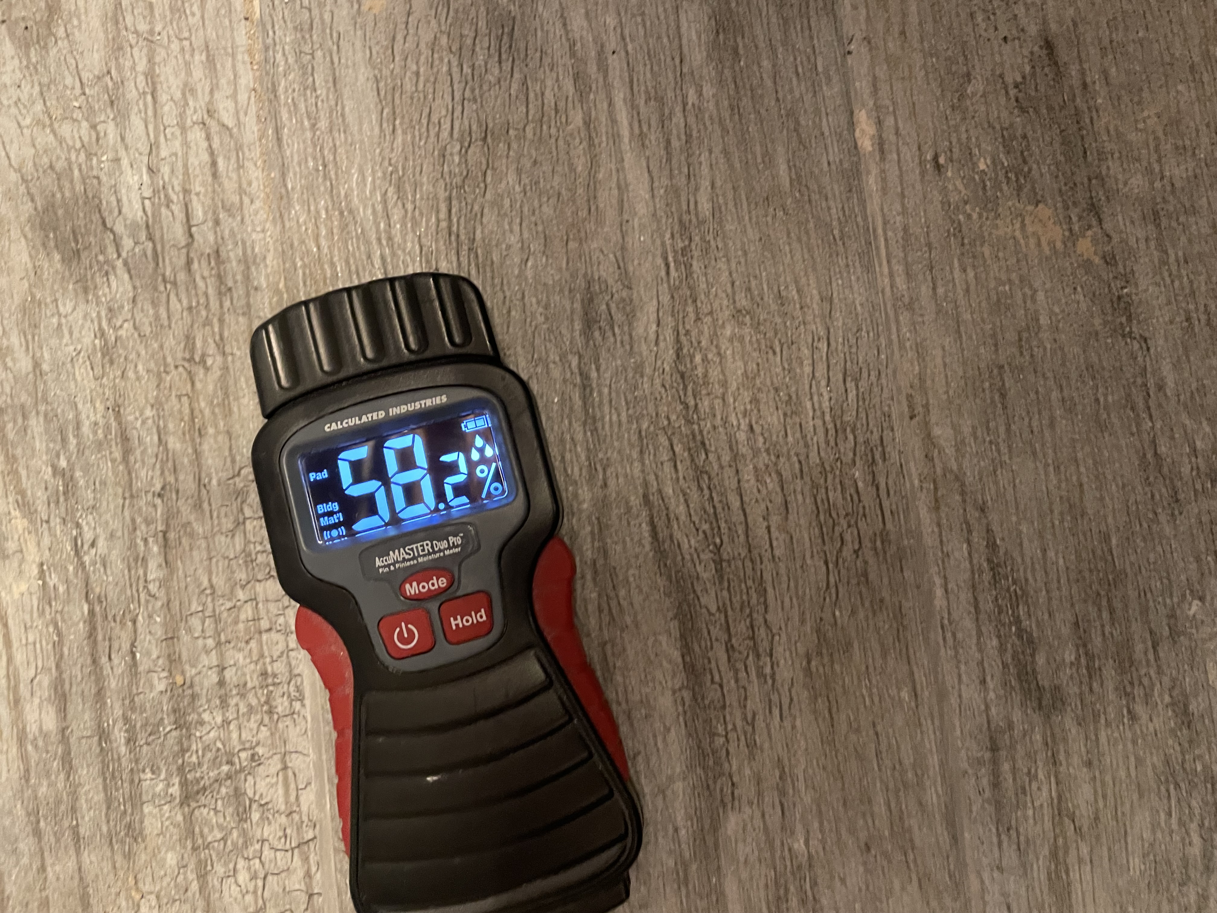 Professional moisture meter assessment tool showing readings on damaged wood flooring during restoration evaluation in Freeze_dry_documents_books.htm Minnesota